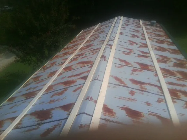 Rusted metal roof panels with new wood purlins before replacement — Storm Damage Roof Repair in Neelyton by Roofing Brothers