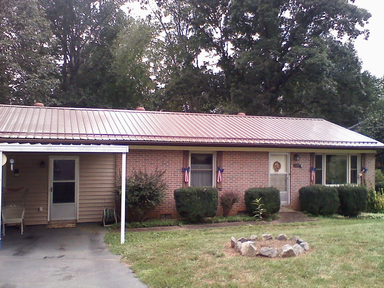 Bronze metal roof and carport on a brick ranch home — Roof Repair work by our crew in Neelyton