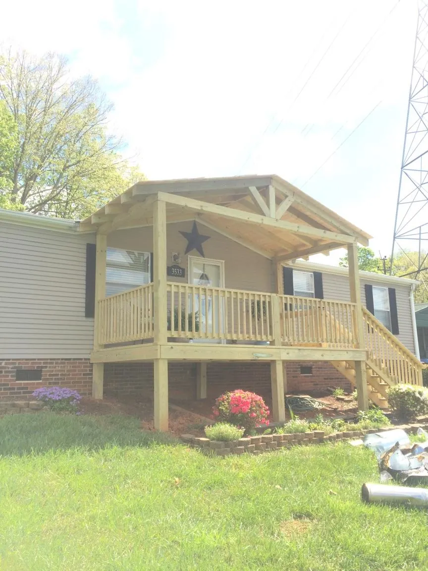 New gabled porch roof and deck railing added to a ranch home in Neelyton